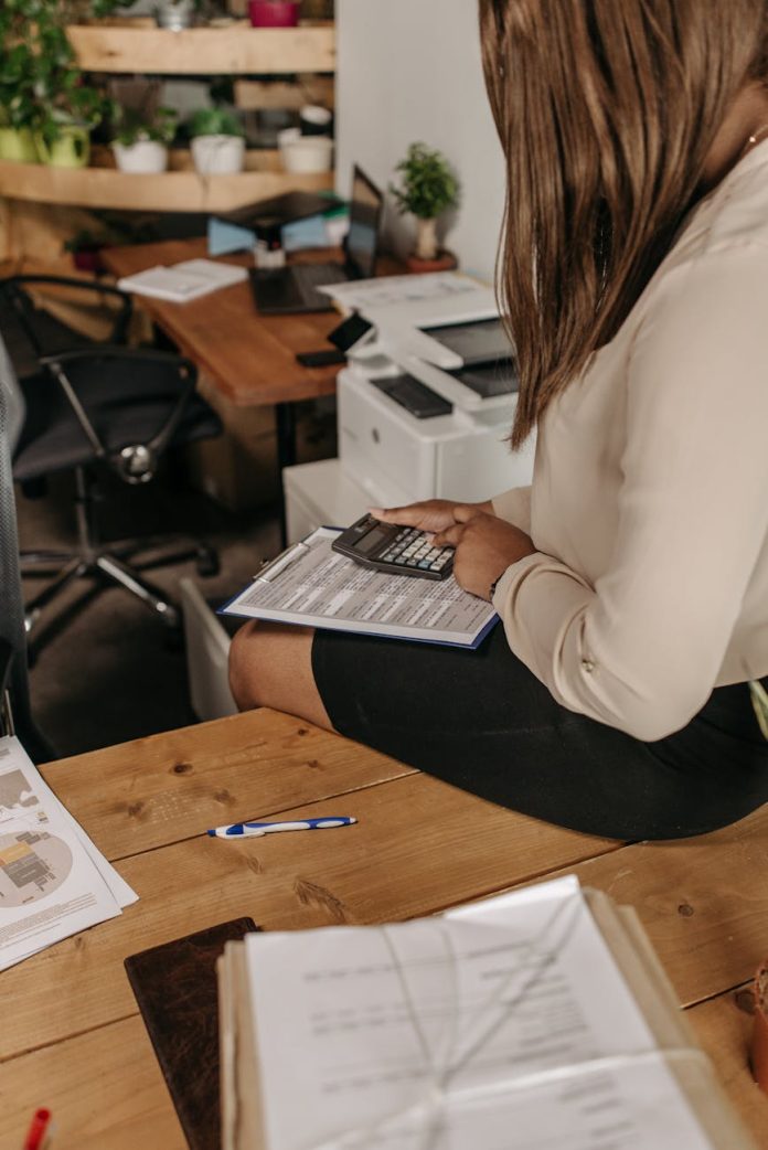 A book lies next to an Apple TV remote control on a dark surface.