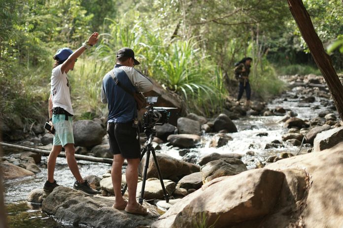 Image of a blurred audience watching a documentary screen.
